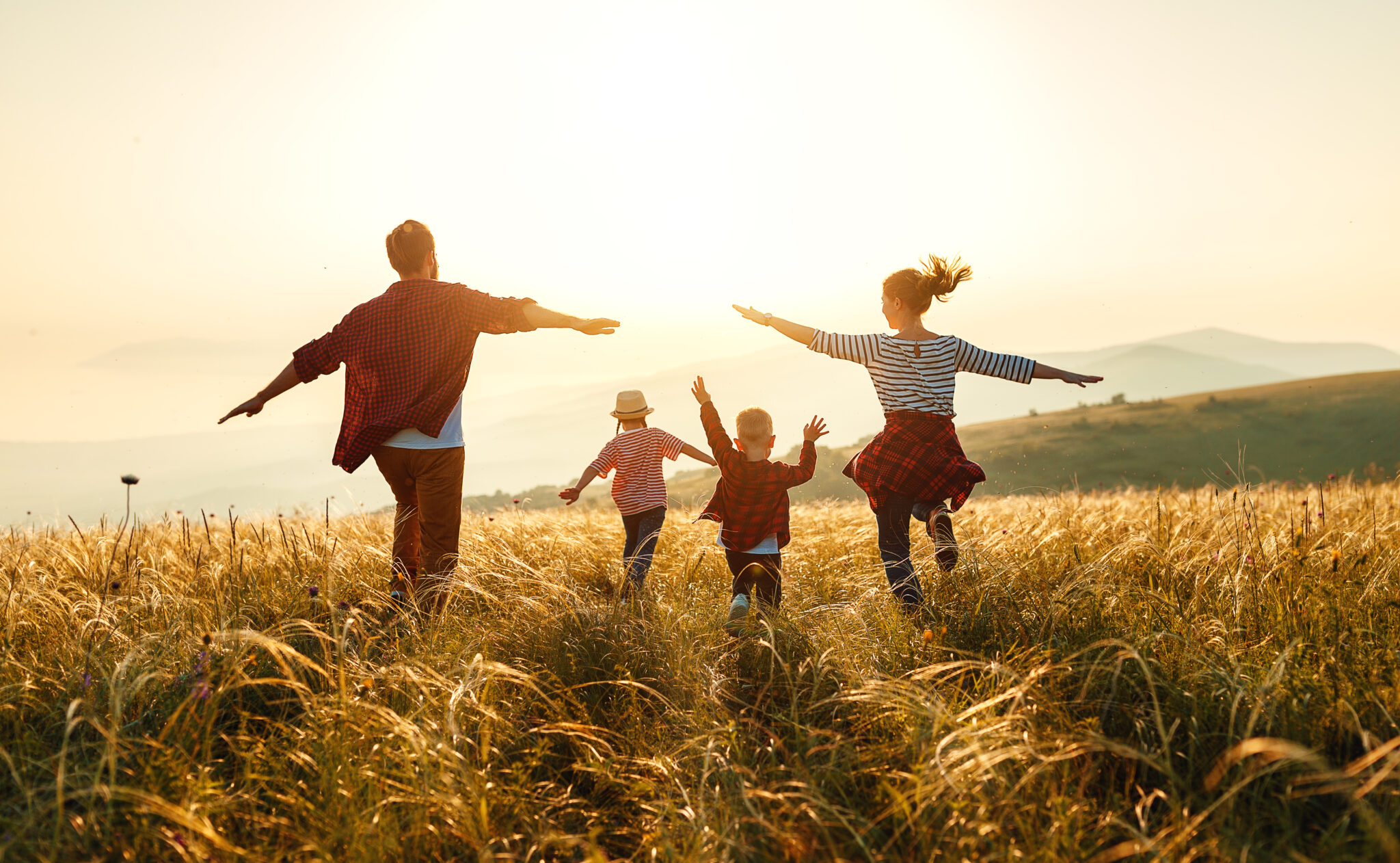 Happy family: mother, father, children son and daughter on sunset